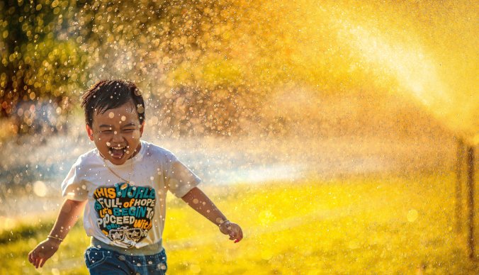 Barn som løper gjennom spreder på en sommerdag