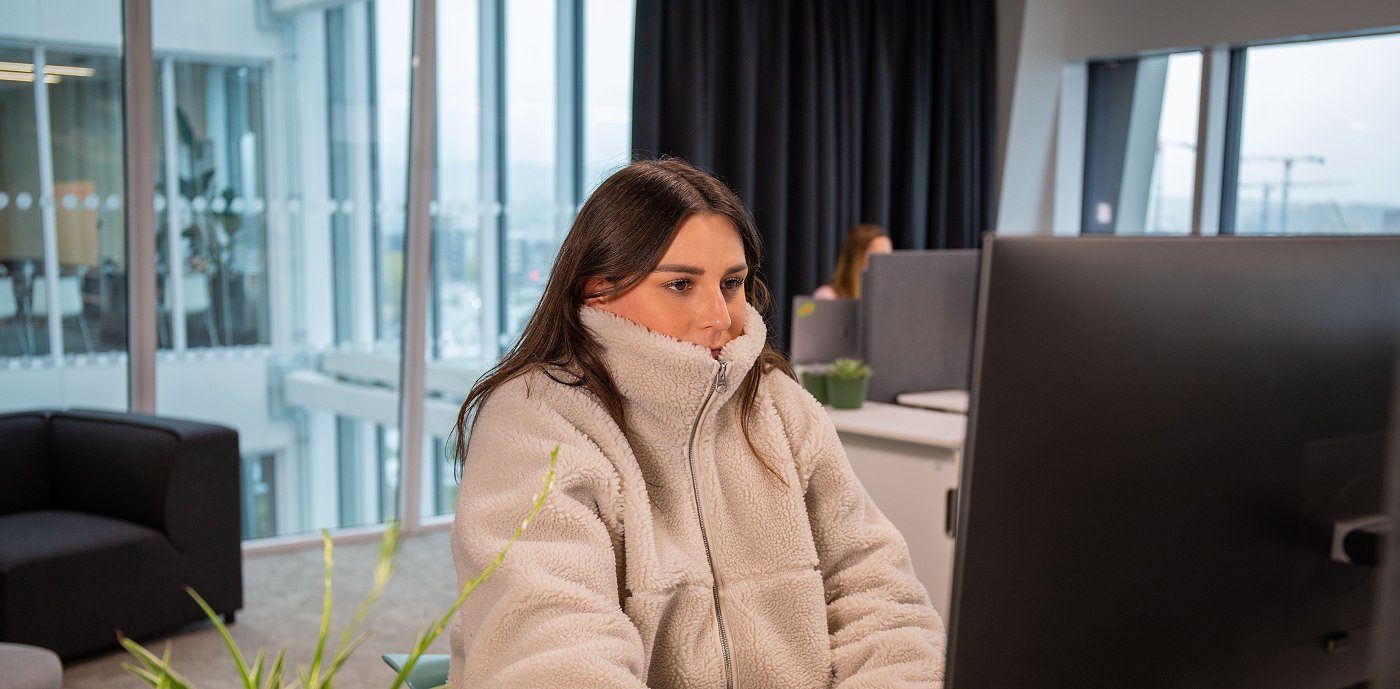 Kvinne som fryser på kontoret. Foto: GK Gruppen AS