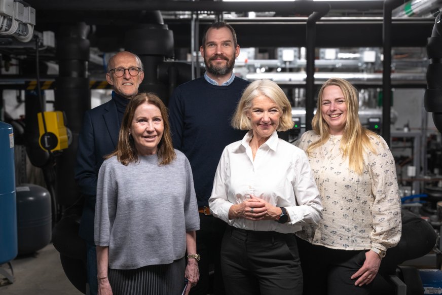 Fem mennesker står i et teknisk rom