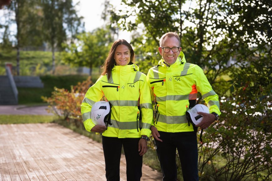 Bilde av Martine Drevvatne HMS-sjef, og Kim Robert Lisø, konsernsjef i GK med arbeidsklær og arbeidshjelm i hånden. 