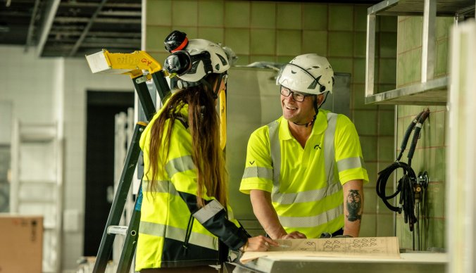 To medarbeidere i GK foran en skisse på byggeplass