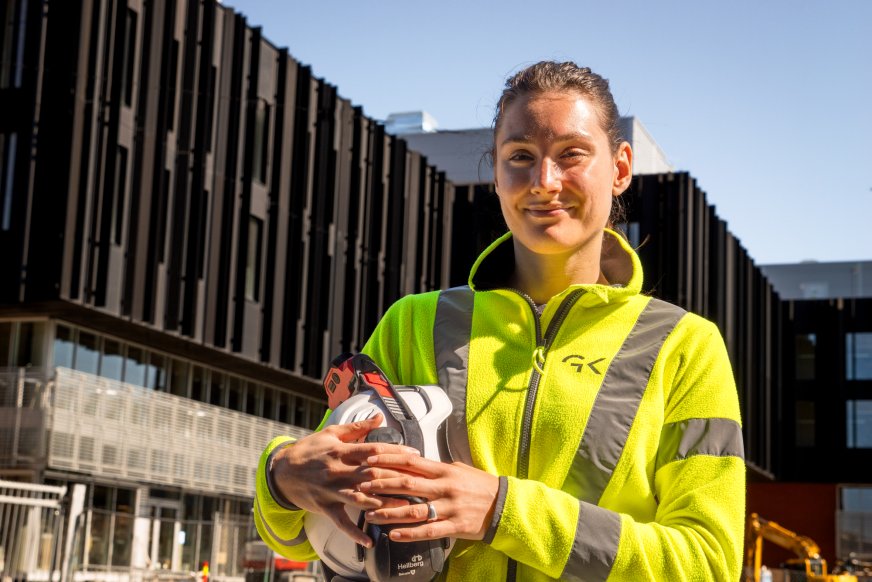 Brita Sandland i GK stående foran Livsvitenskapsbygget i Oslo med hjelm i hånden.