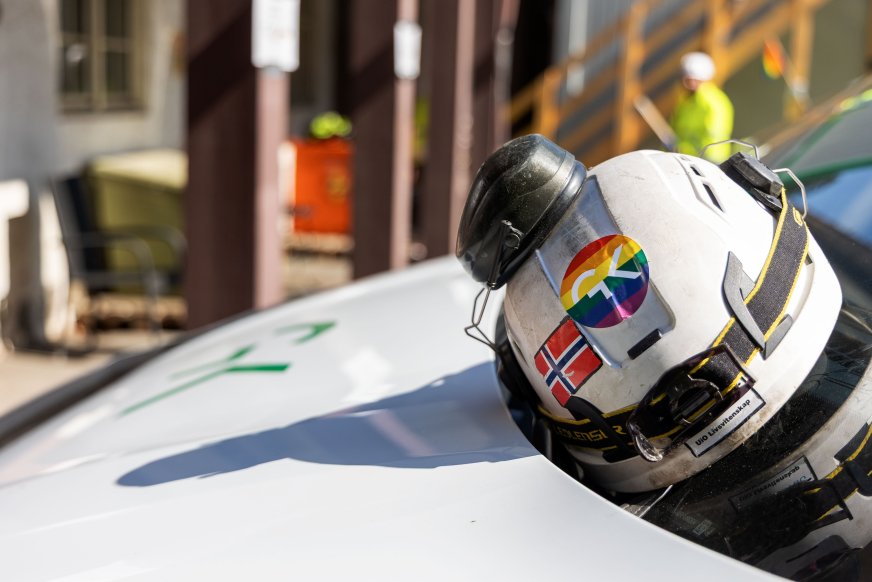 Hjelm med GK-logo i Pride-farger.