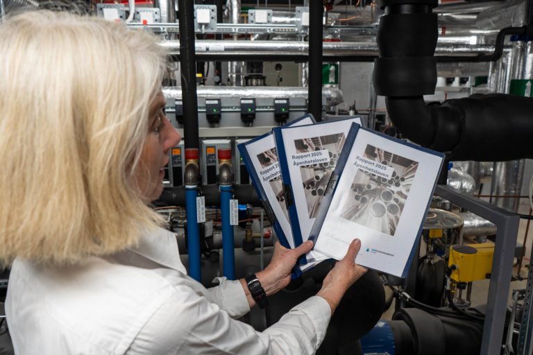 Kvinne holder rapporten Åpenhetsloven 2025.