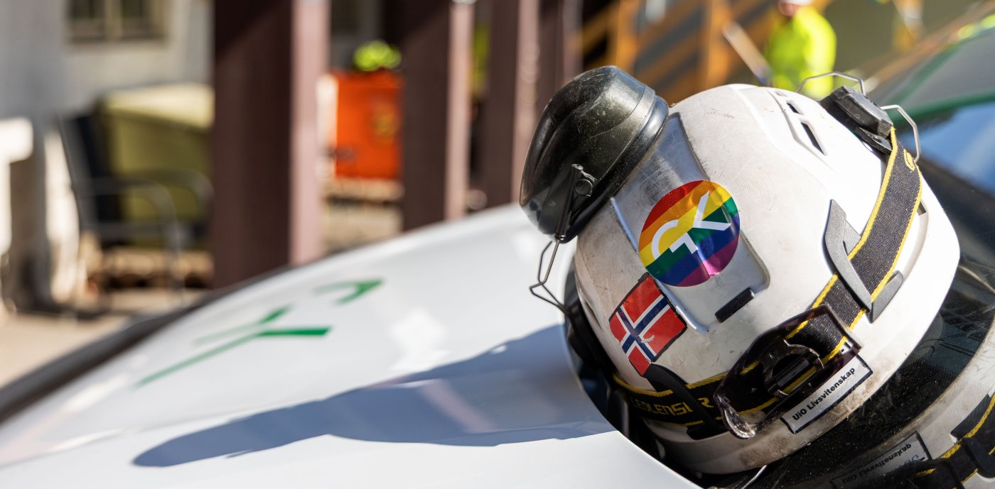 Hjelm med GK-logo i Pride-farger.