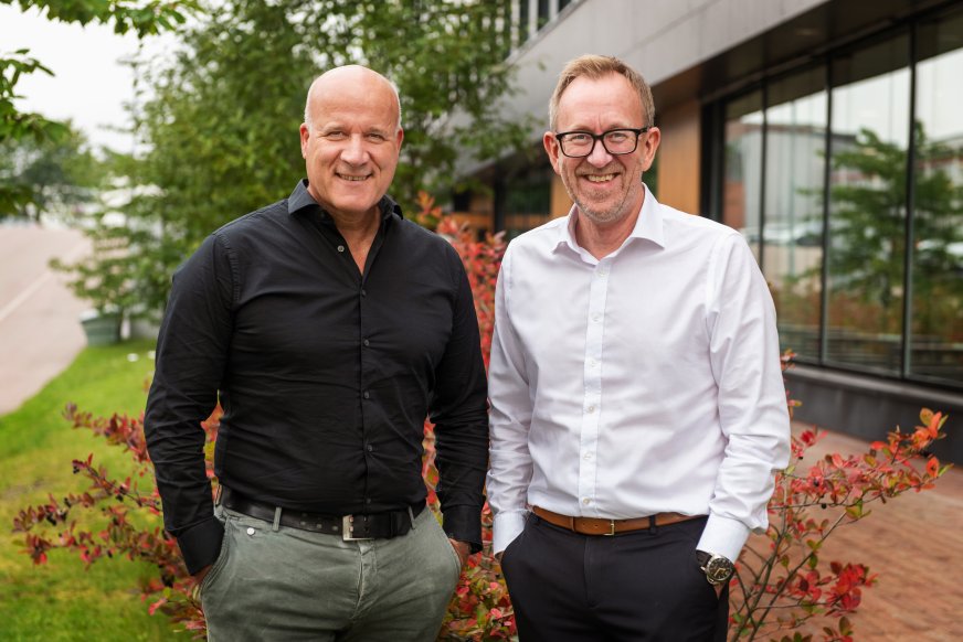 Bilde av Kim Robert Lisø, konsernsjef GK og Leif Øie, divisjonsdirektør entreprise GK Norge, utendørs foran GKs kontor i Oslo med trær i bakgrunnen